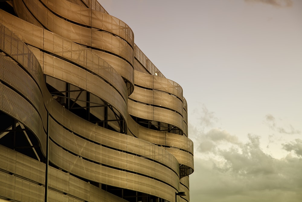 a tall building with a curved roof and a sky background