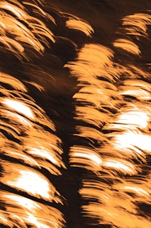 An abstract orange waveform graphic glowing against a dark background, symbolizing sound energy.