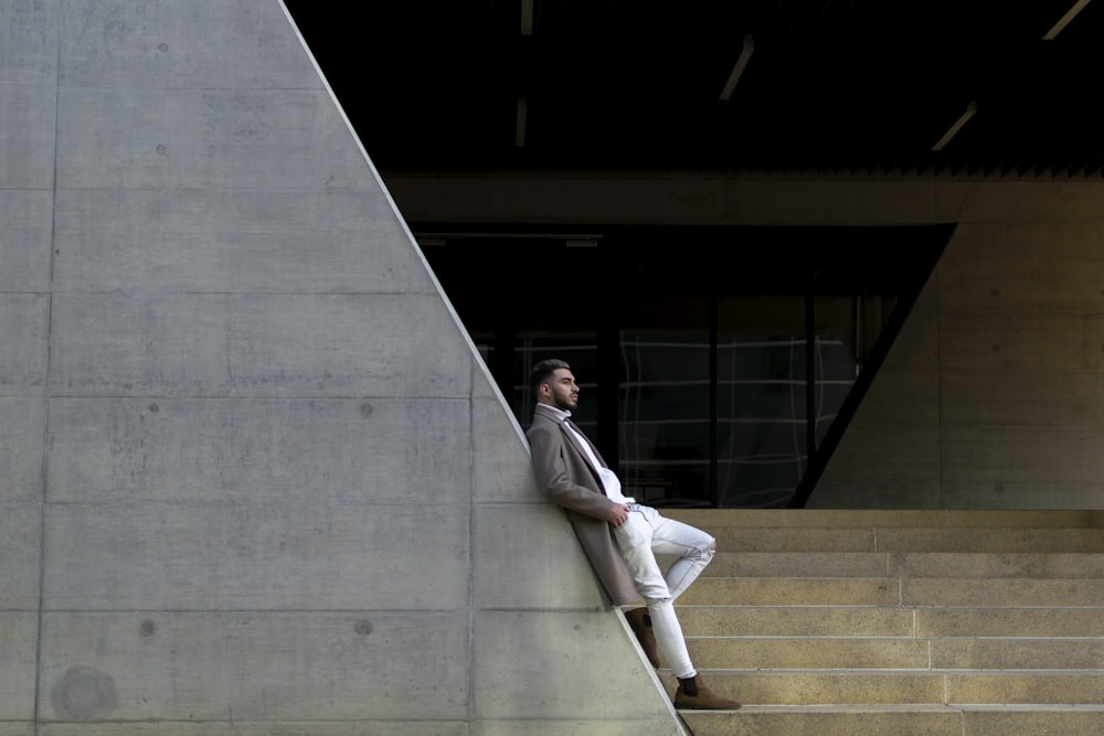 Ein Mann sitzt auf den Stufen eines Gebäudes