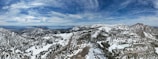 A panoramic view of snow-capped mountains with a winding road below.