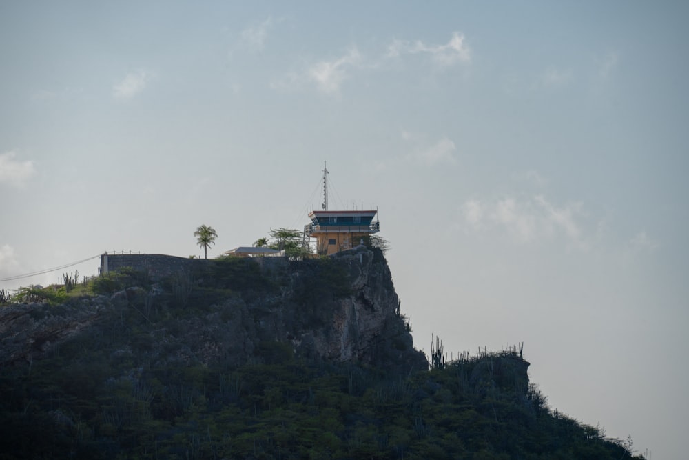 a house on top of a mountain with a sky background