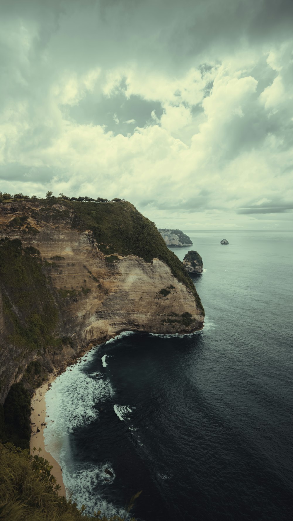 a large body of water sitting next to a lush green hillside