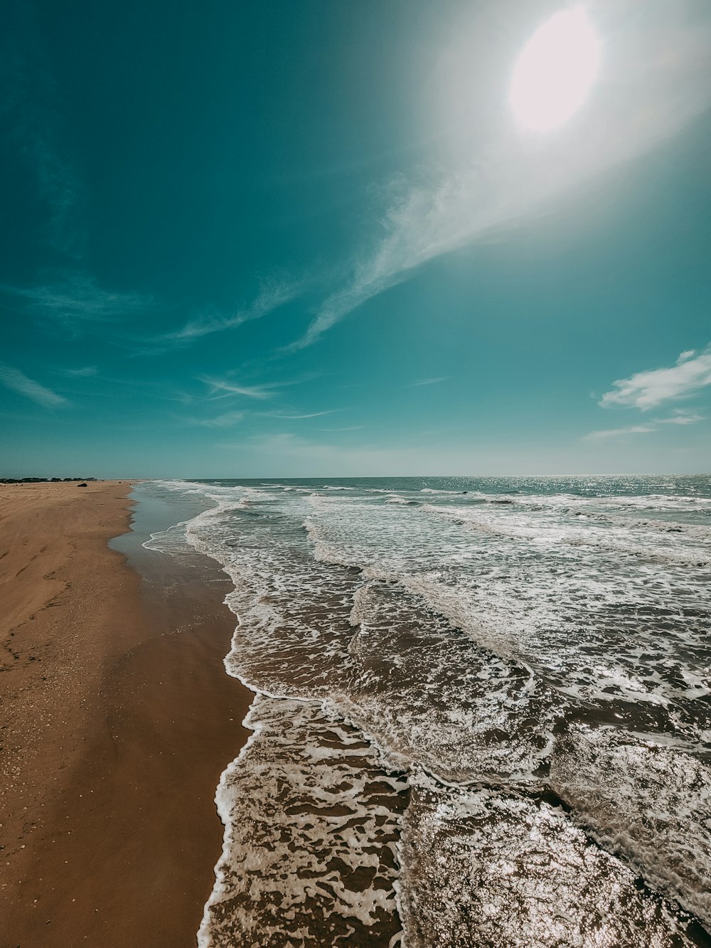 a sandy beach with waves coming in to shore