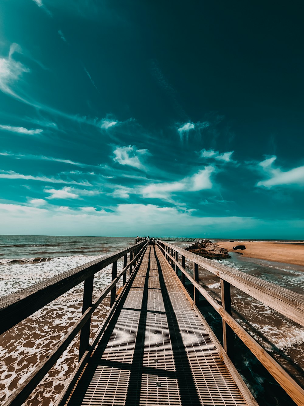 a long wooden pier stretches out into the ocean