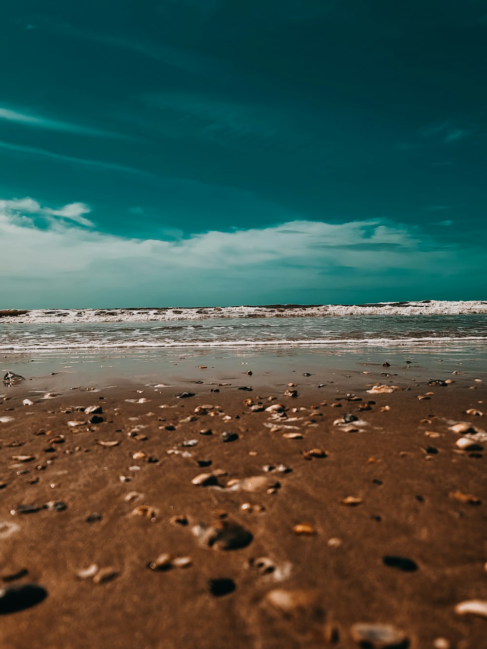 a person walking on a beach with a surfboard