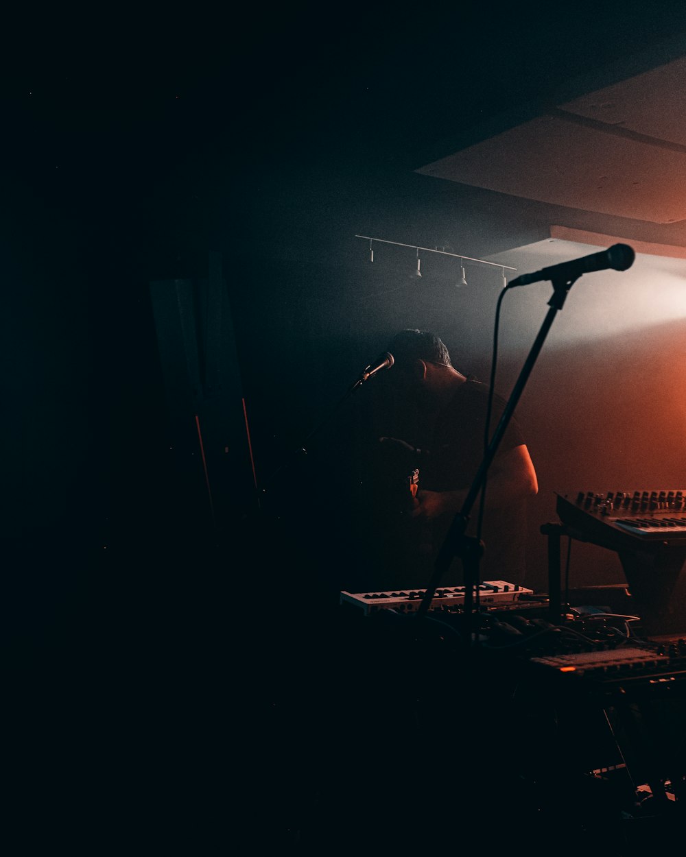 a person standing in front of a microphone in a dark room