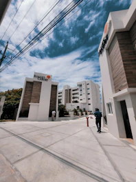 a man walking down a street next to tall buildings