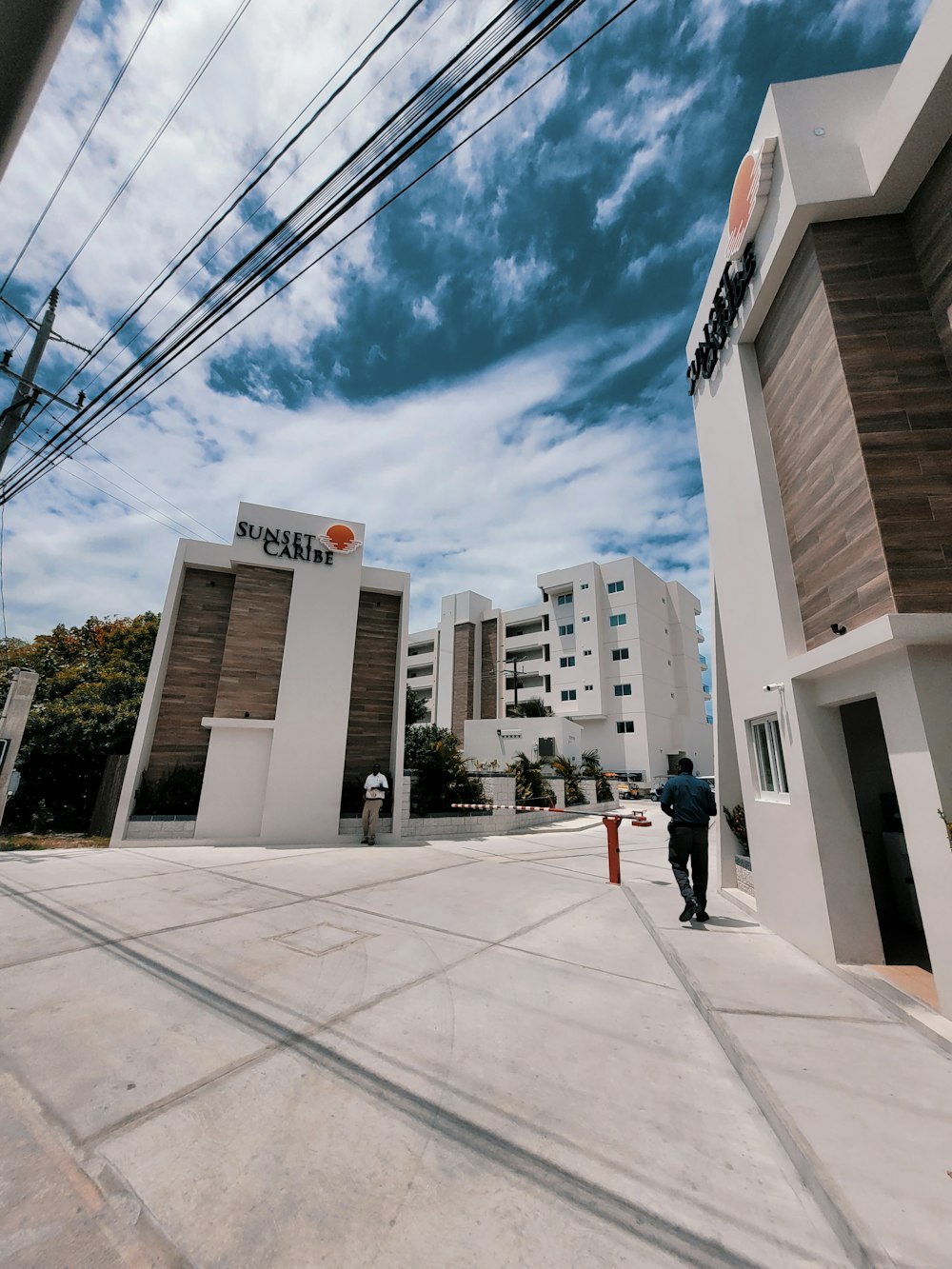 a man walking down a street next to tall buildings