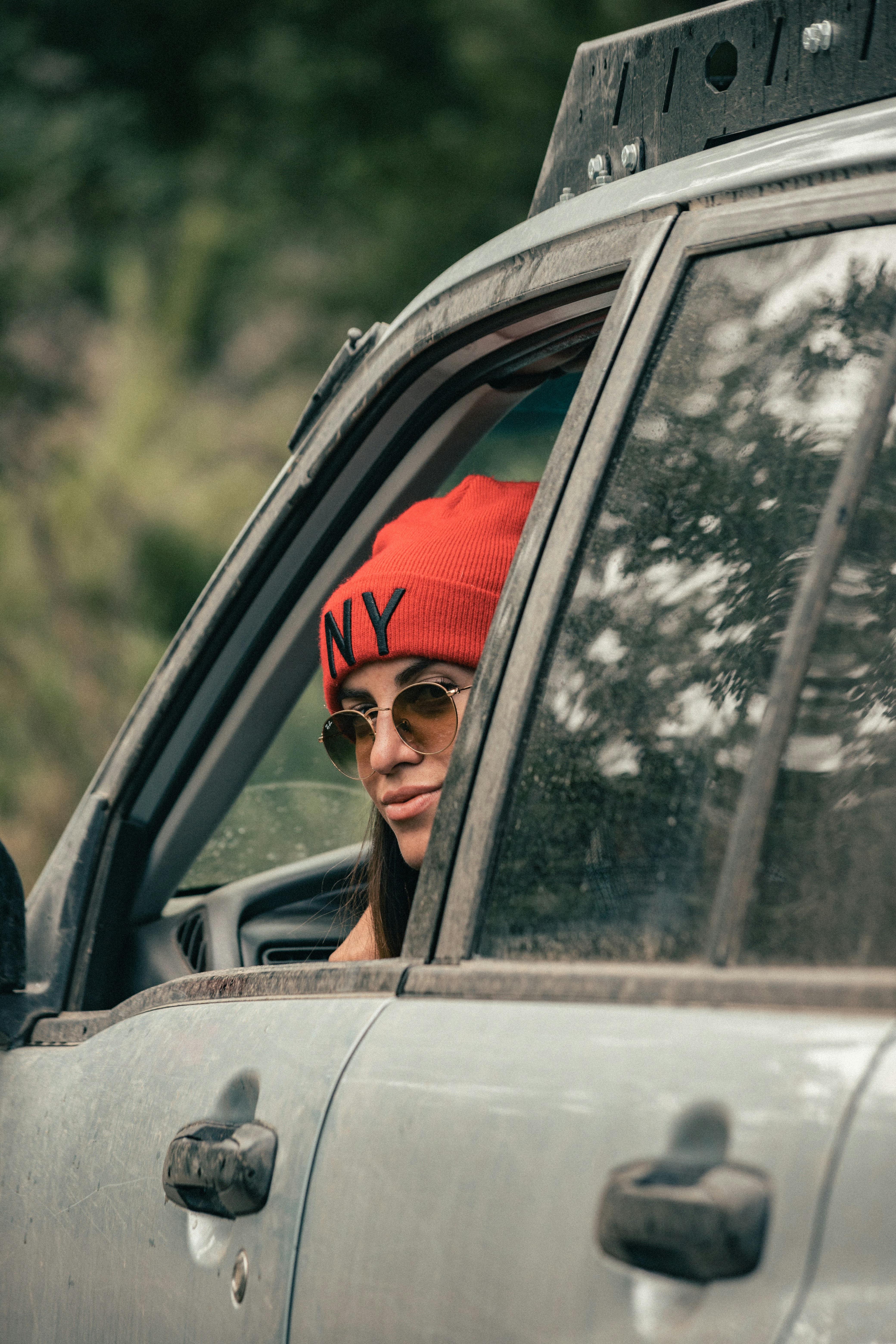 Fotomural a woman wearing a red hat and sunglasses sitting in a car