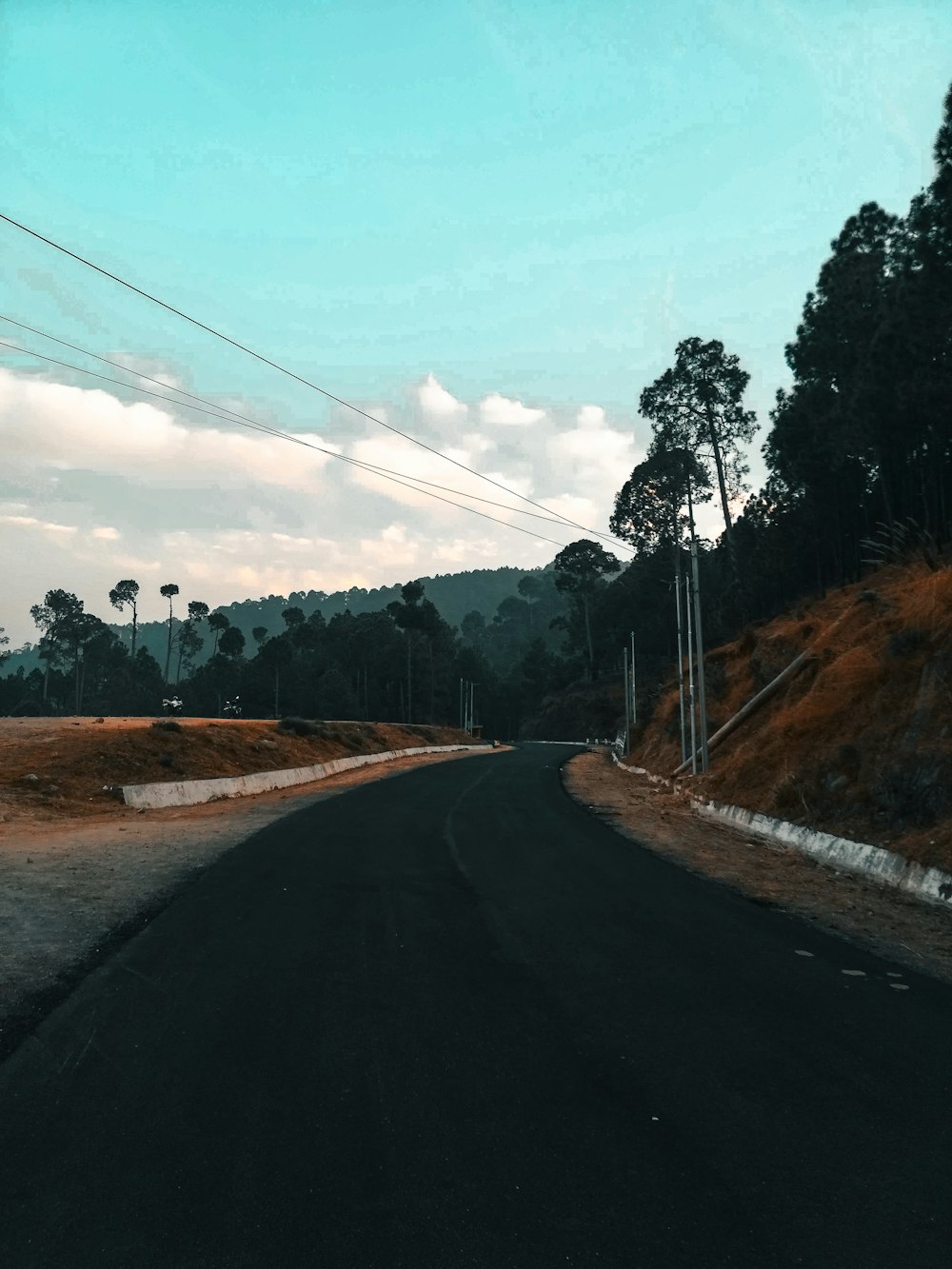 Una strada con una collina sullo sfondo