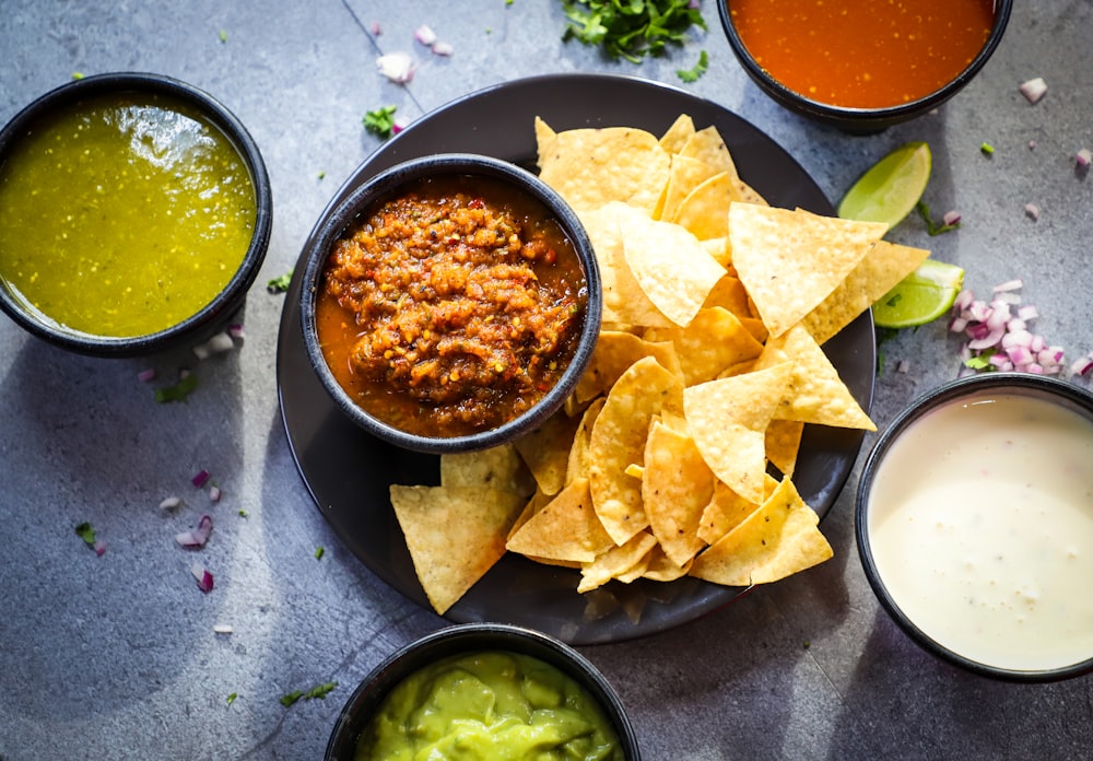 a plate of chips, salsa, and guacamole on a table
