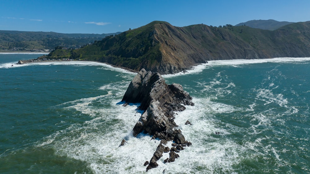 ein großes Gewässer mit einem Berg im Hintergrund