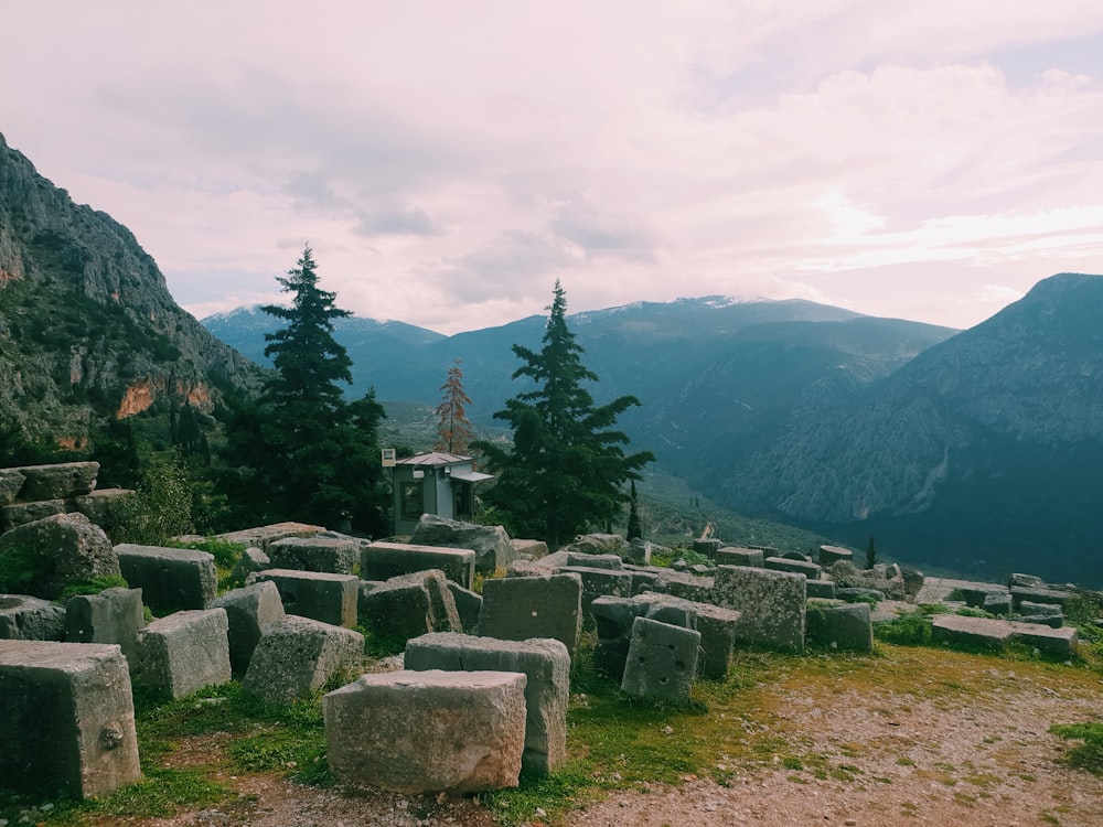 a group of large rocks sitting on top of a lush green hillside