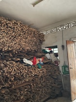 Delivery truck unloading bundles of firewood at a cozy home doorstep.