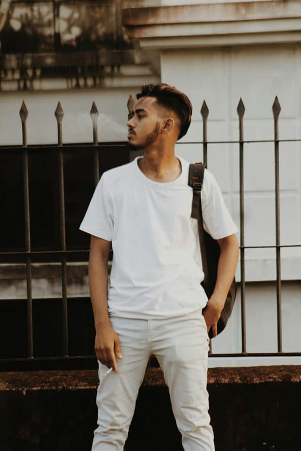 a man with a backpack standing in front of a building