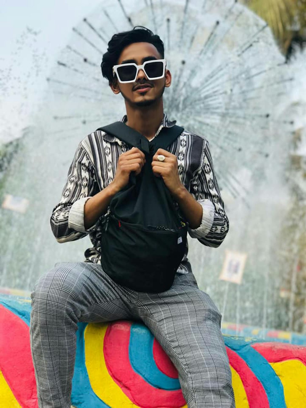 a man sitting on top of a colorful object