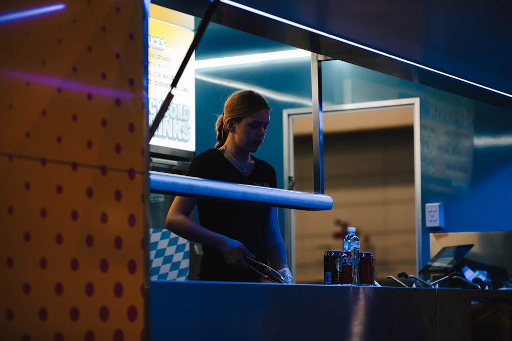 a woman standing at a counter in a restaurant