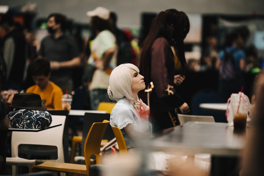 a woman with white hair sitting at a table