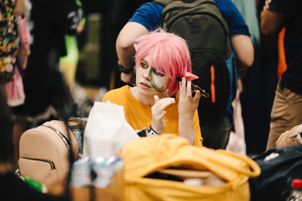 a person with pink hair and makeup on