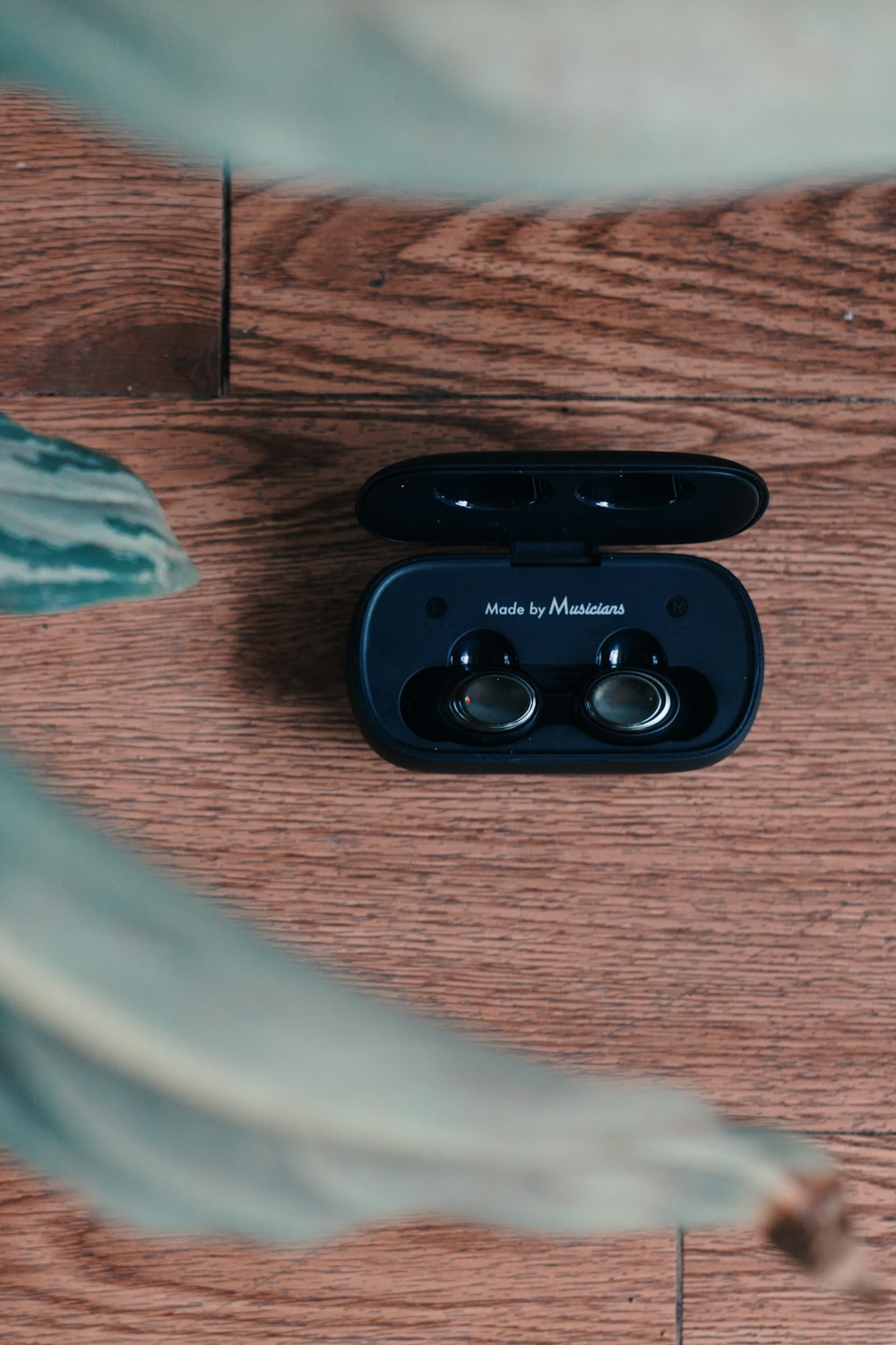 a pair of ear buds sitting on top of a wooden table