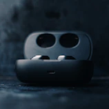 A close-up of wireless earbuds resting on a charging case with soft lighting.