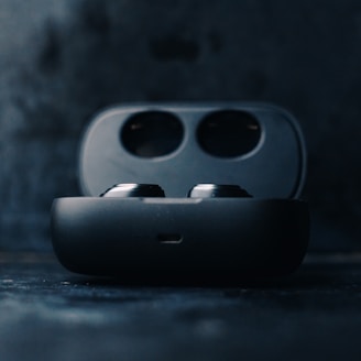 Close-up of wireless earbuds resting in their charging case with soft lighting