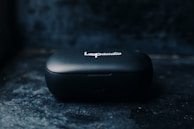 A small, black portable device case with the inscription 'Loop audio' on top, positioned against a dark and slightly textured background.