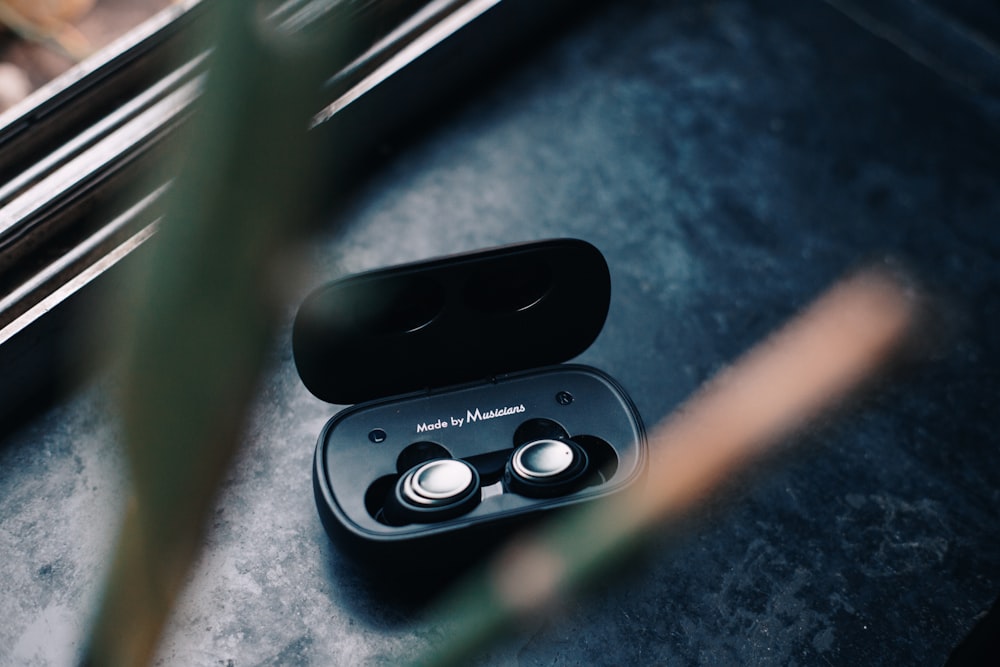 a pair of black earbuds sitting on top of a table