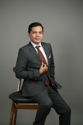 a man in a suit sitting on a chair