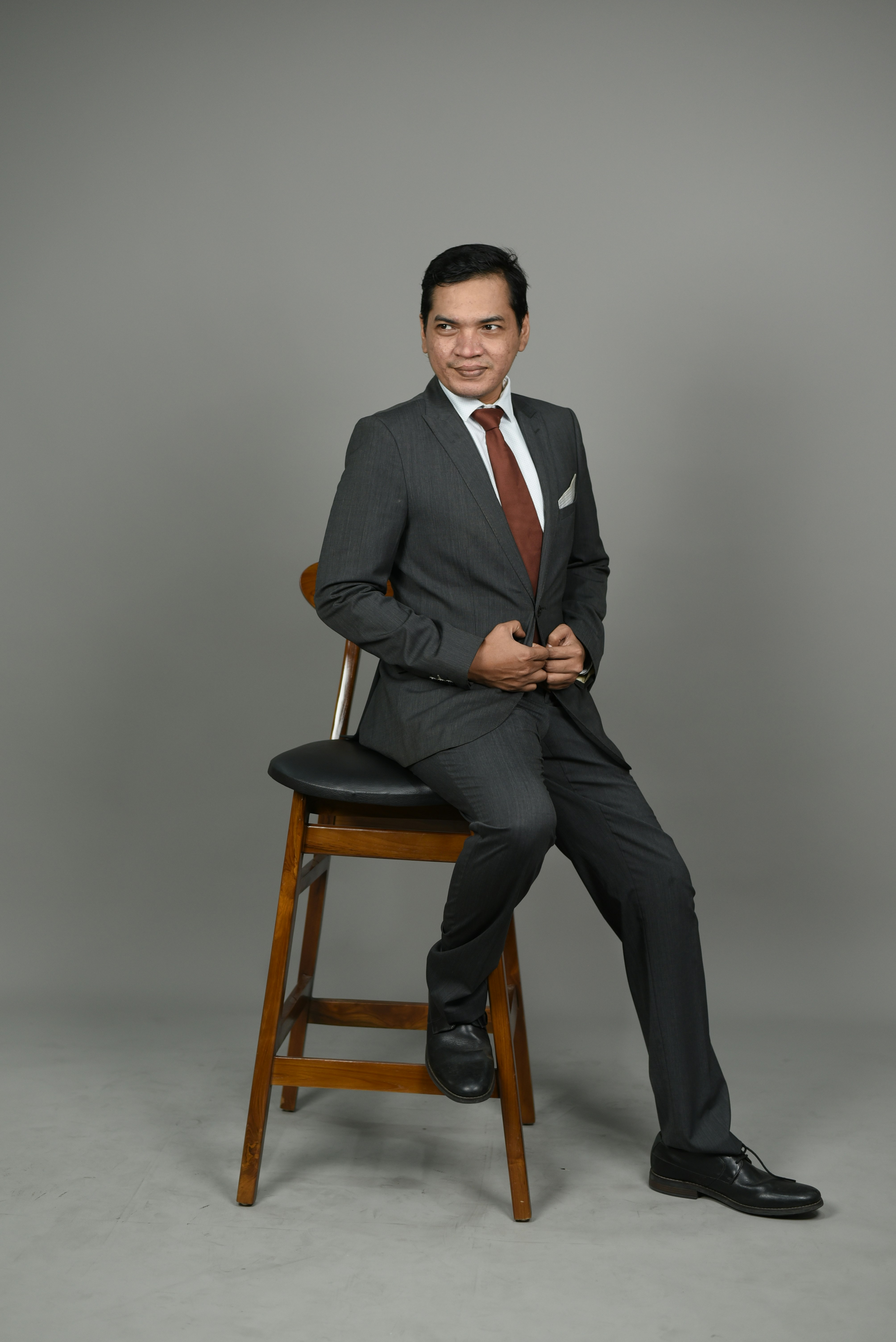 a man in a suit sitting on a chair
