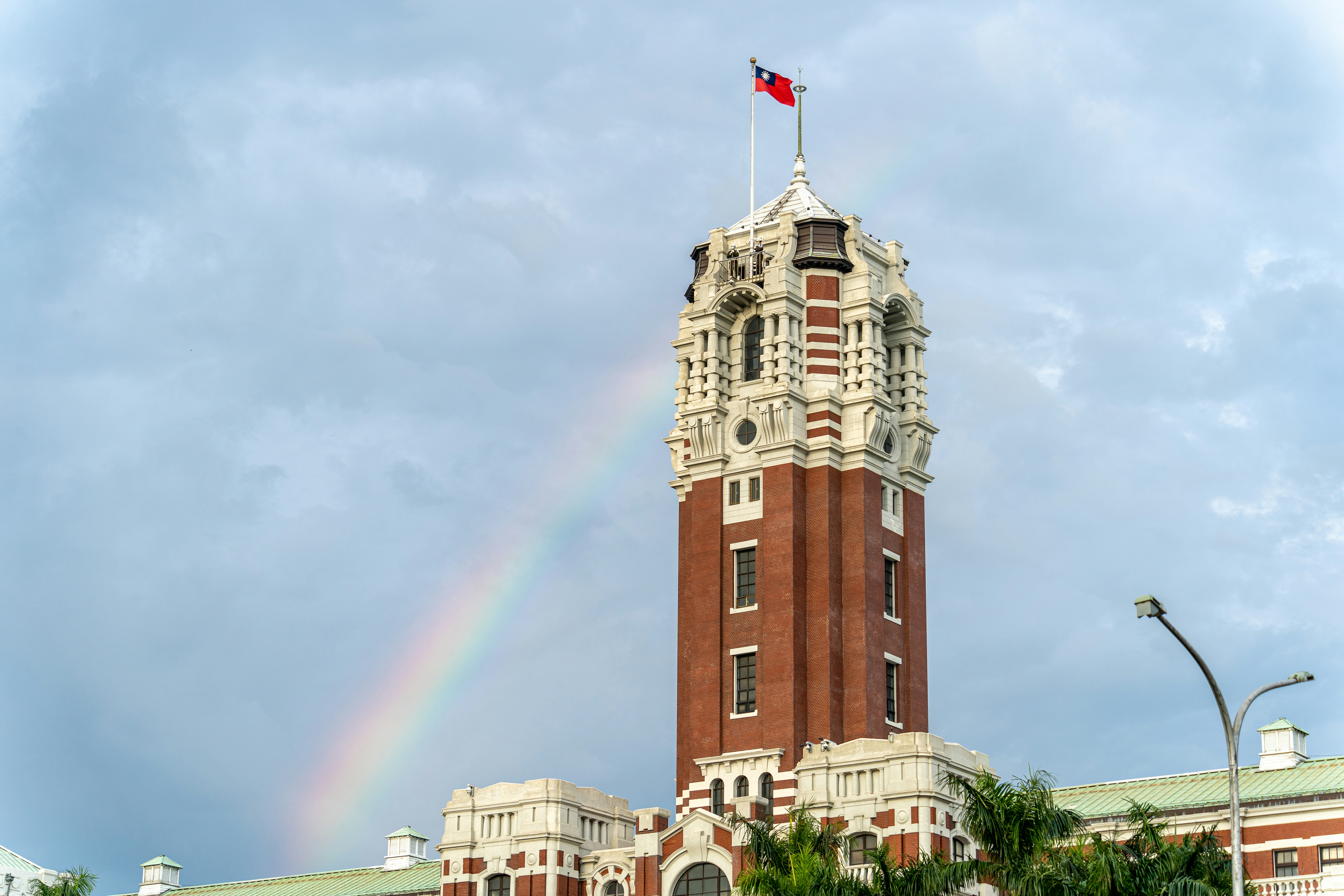 Un edificio alto con un arco iris en el fondo