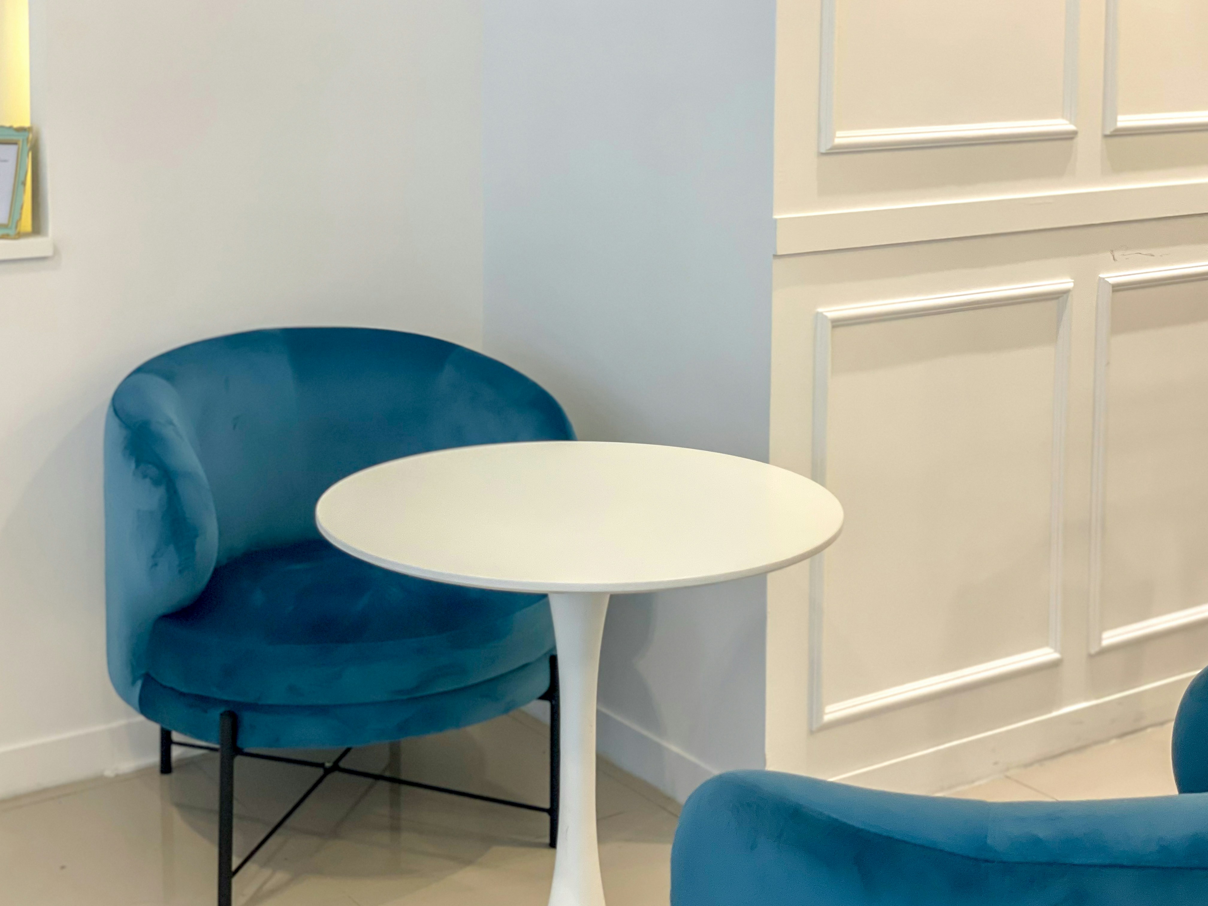 a blue chair and a white table in a room
