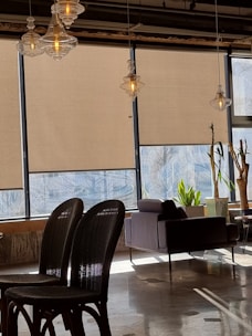 A modern living room with freshly cleaned roller blinds hanging on the window.