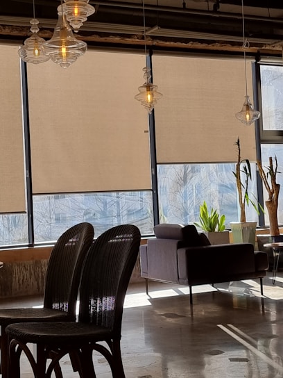 A bright Miami living room featuring sleek motorized roller shades partially drawn, showcasing a modern and cozy atmosphere.