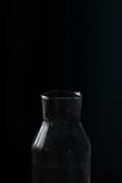 Glass bottle of pure black seed oil with natural light highlighting its rich amber color.