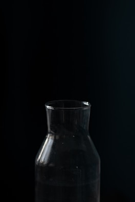 Glass bottle of pure black seed oil with natural light highlighting its rich amber color.