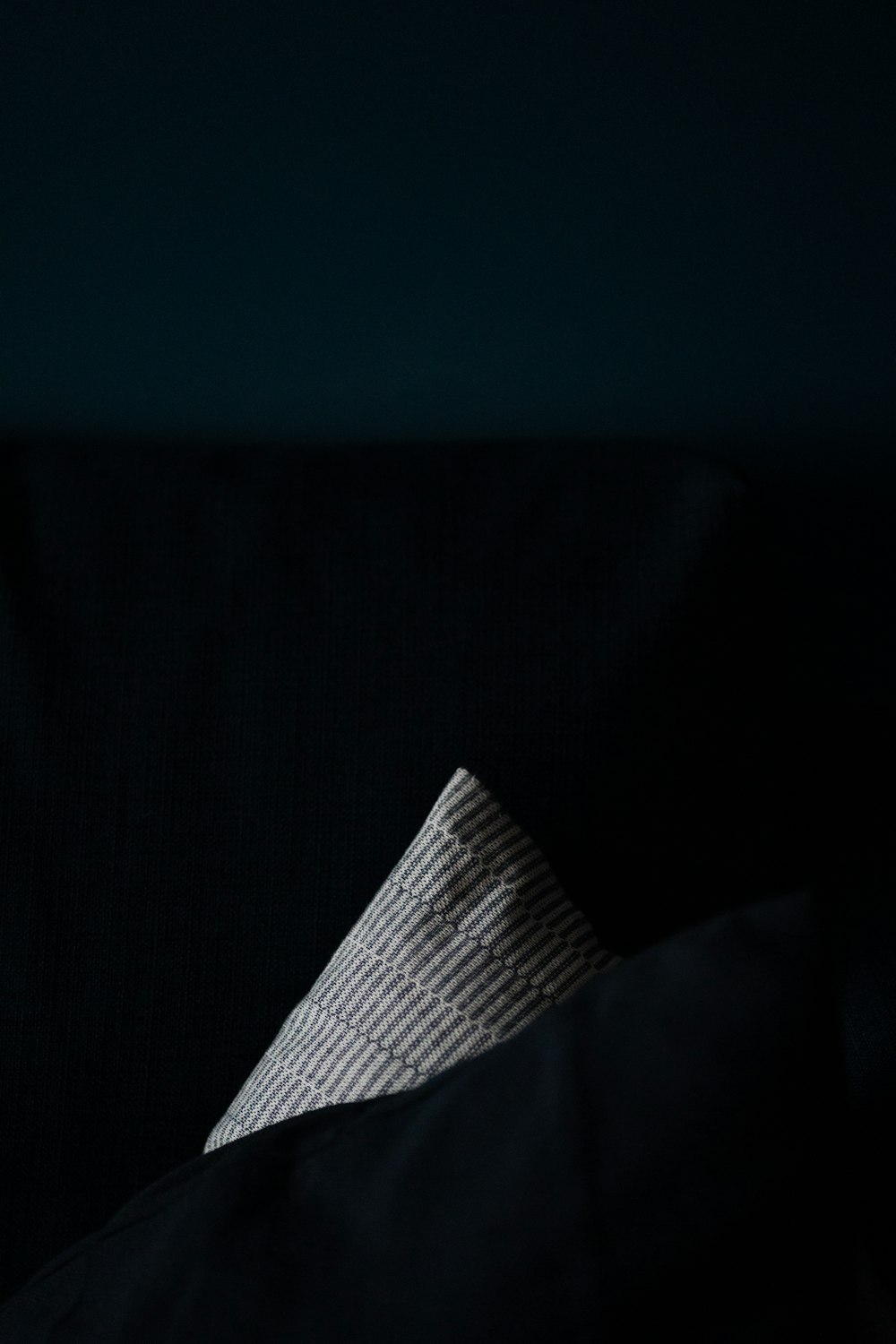 a folded piece of cloth sitting on top of a black couch