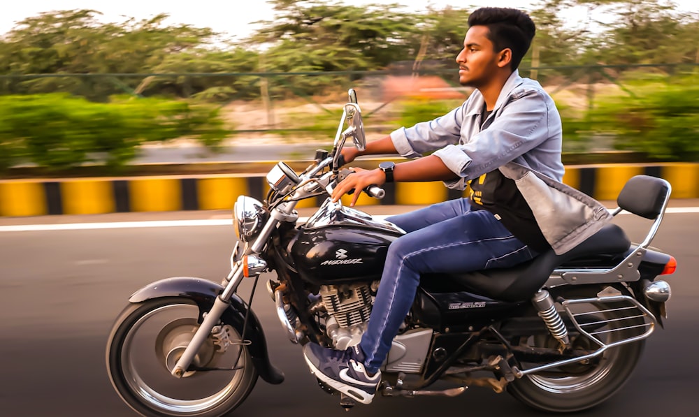 a man riding on the back of a motorcycle down a street