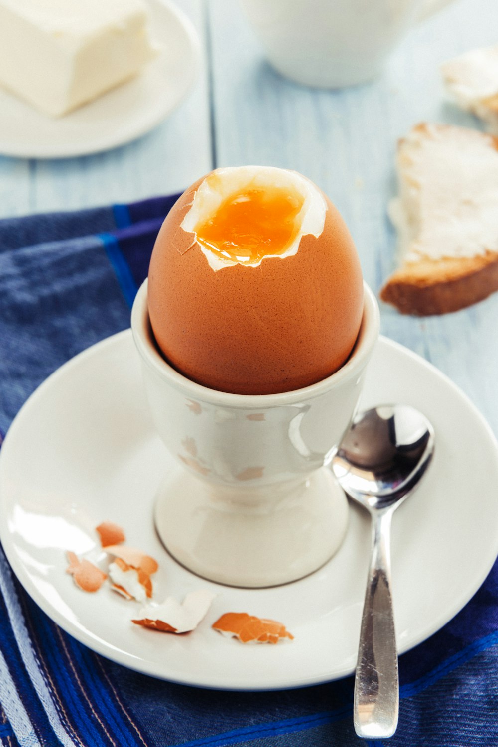 a cracked egg in a white bowl on a white plate