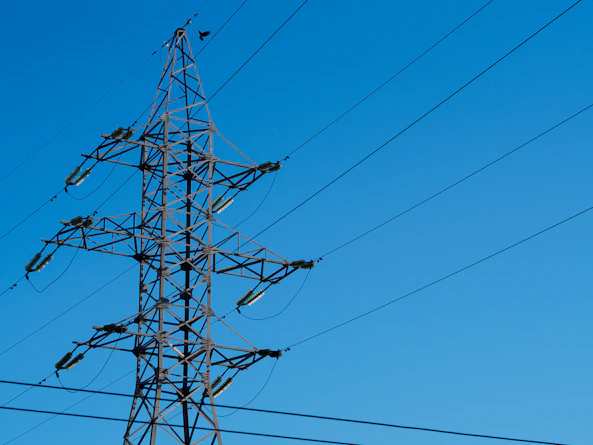 a high voltage power line with a blue sky in the background