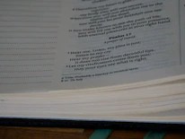 Close-up of worn hands holding an open Bible with a highlighted Psalm 34:18 verse.