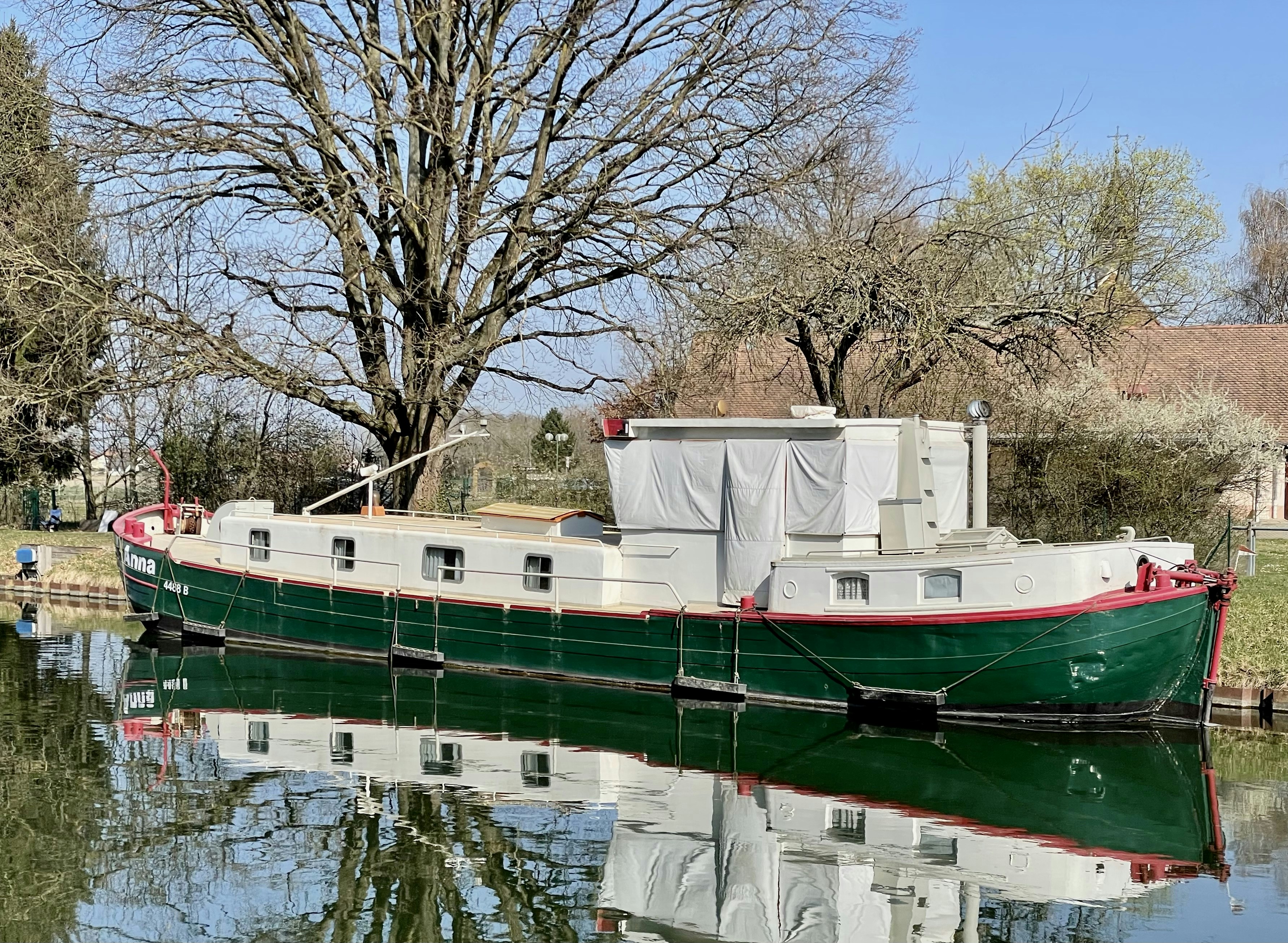 a green and white boat sitting on top of a body of water
