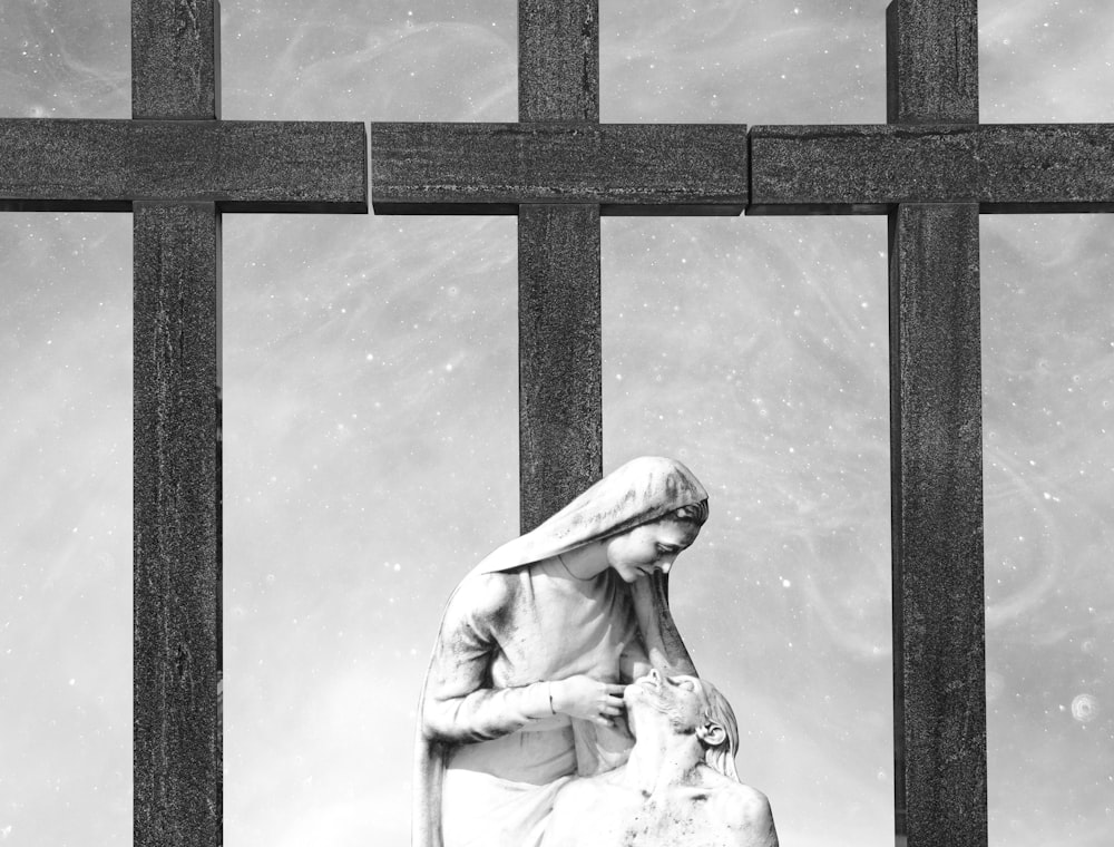 a black and white photo of a statue of a woman holding a lamb