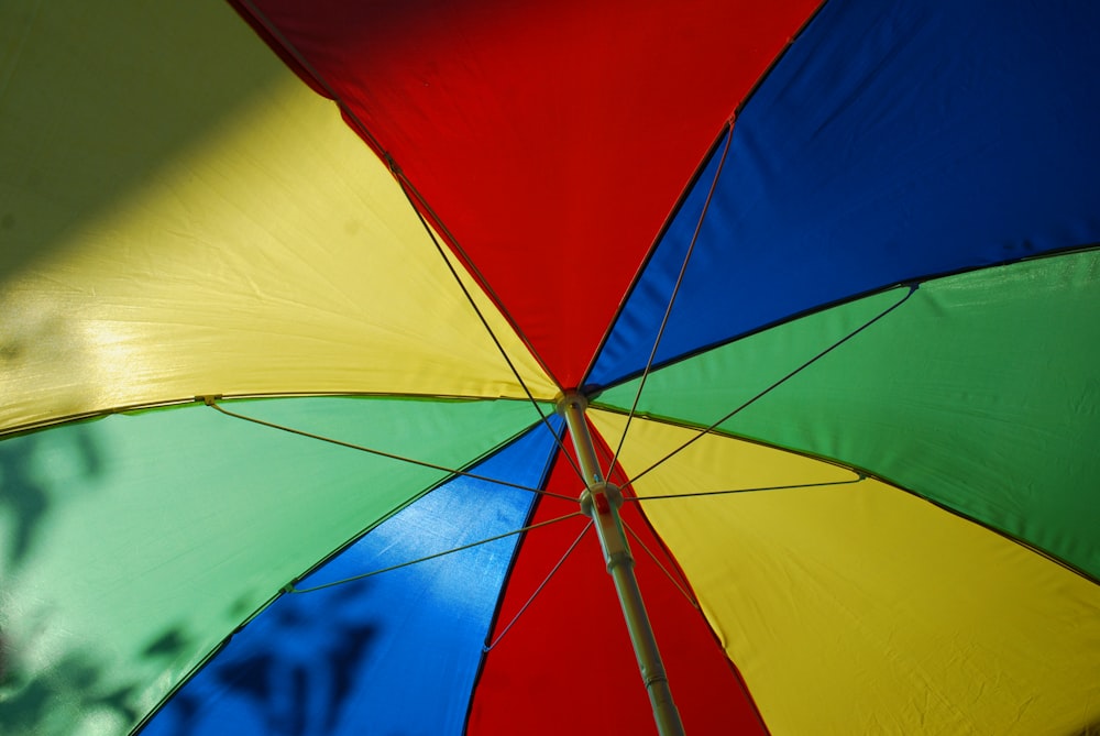 a multicolored umbrella with a tree in the background