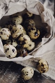 Farm workers gently collecting fresh quail eggs in rustic baskets.