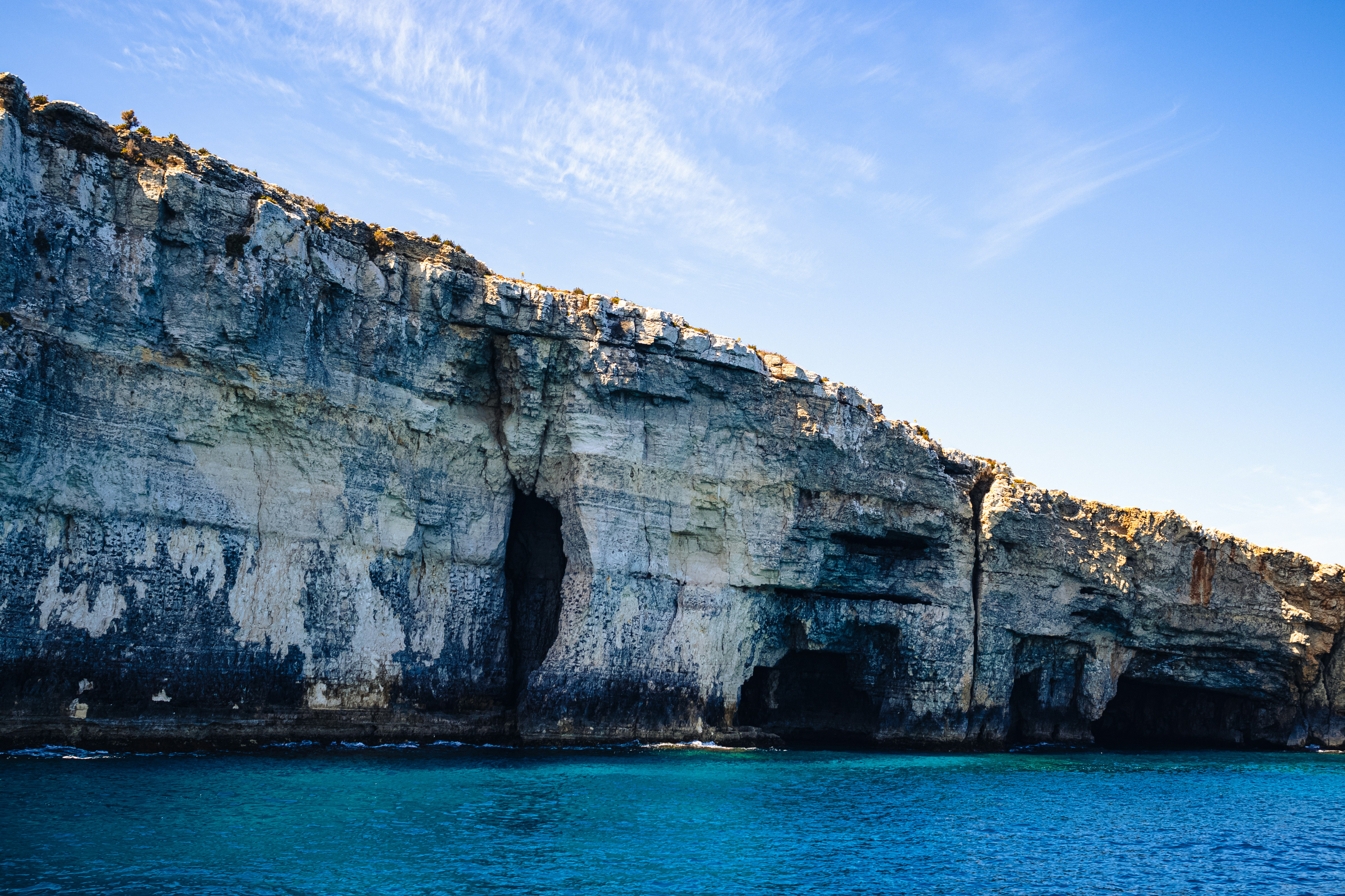 a large cliff with a cave in the middle of it