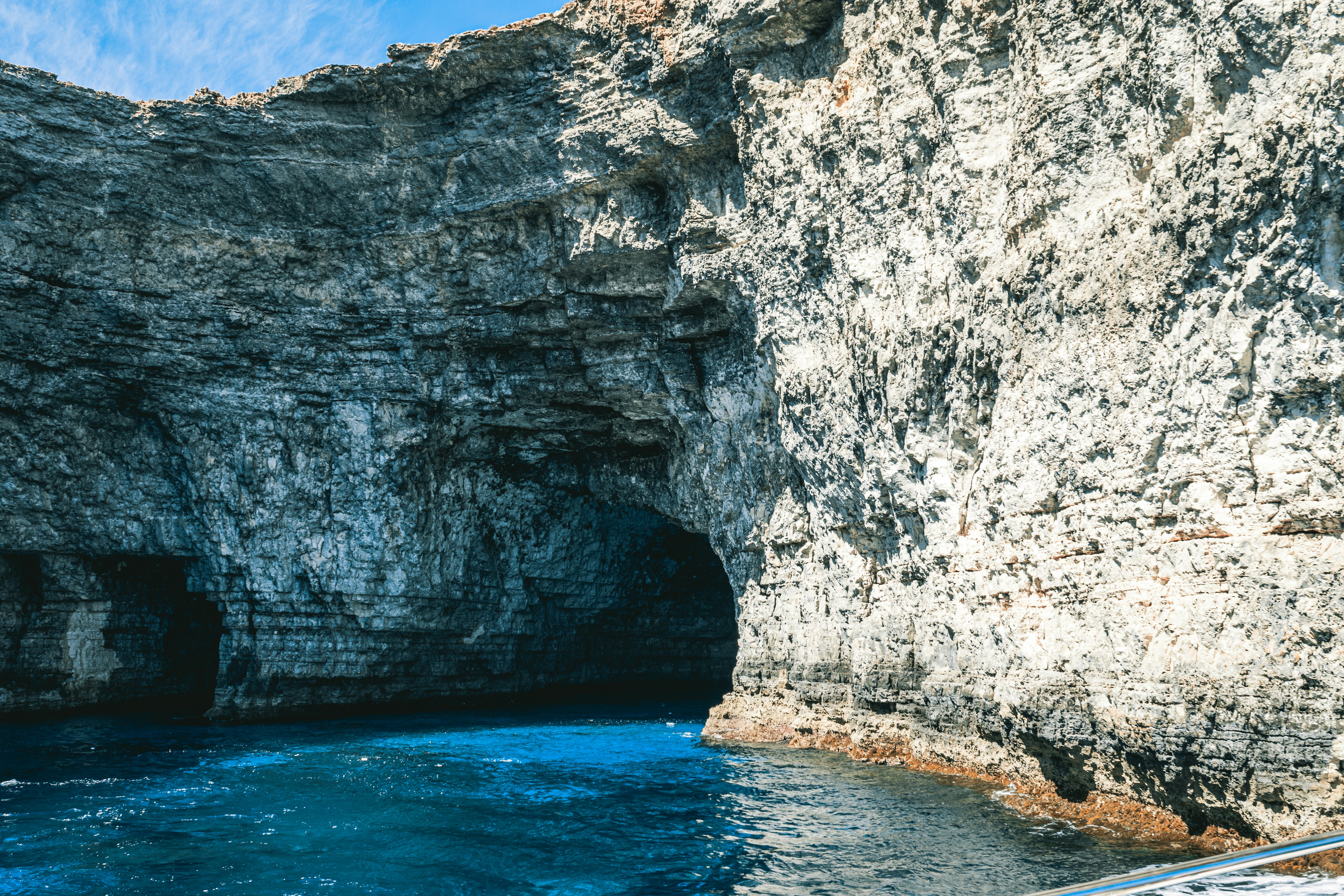 a boat in the water near a large rock formation