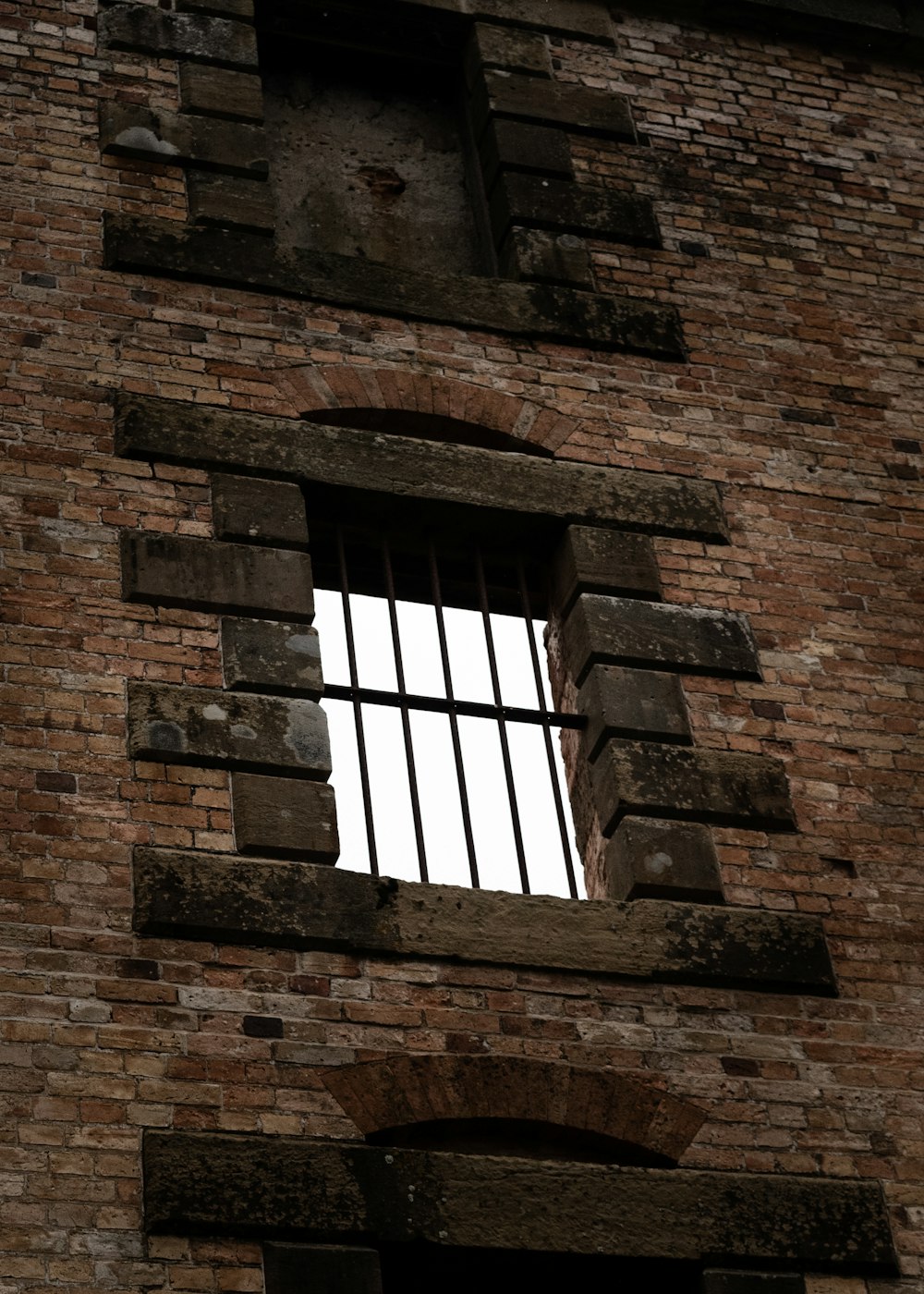 a tall brick building with a barred window
