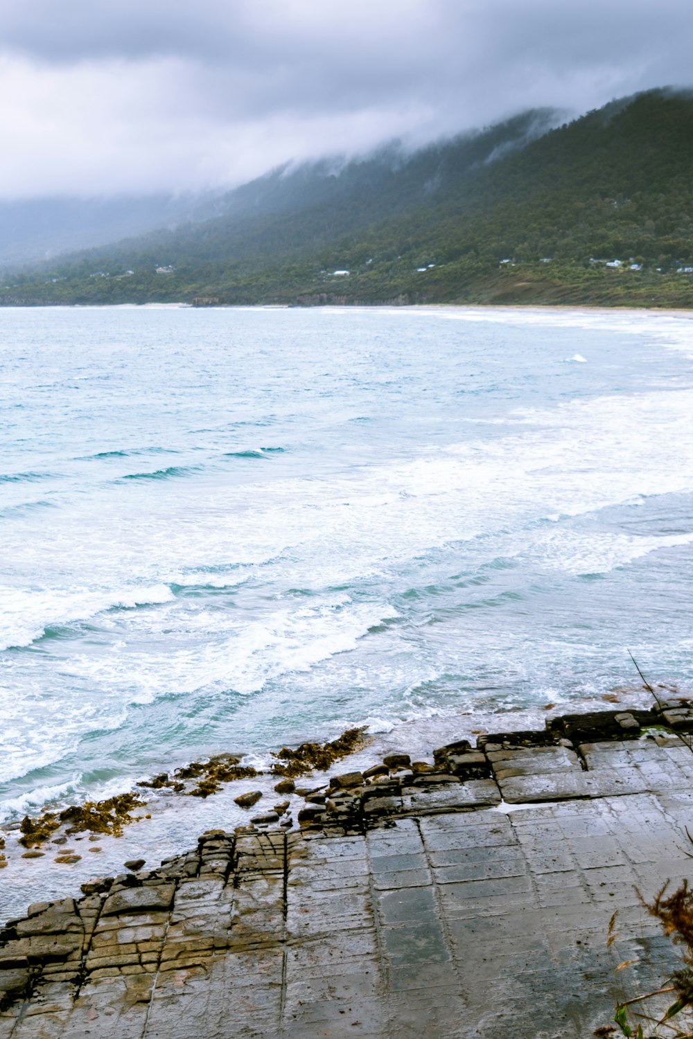 a boat sitting on top of a beach next to the ocean