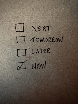 A close-up of a hand ticking off a daily habit checklist with a warm, calming background.